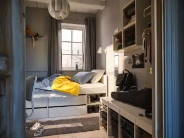 Ett mysigt tonårsrum kille med säng, skrivbord och förvaring. En gul filt och banankudde piggar upp.